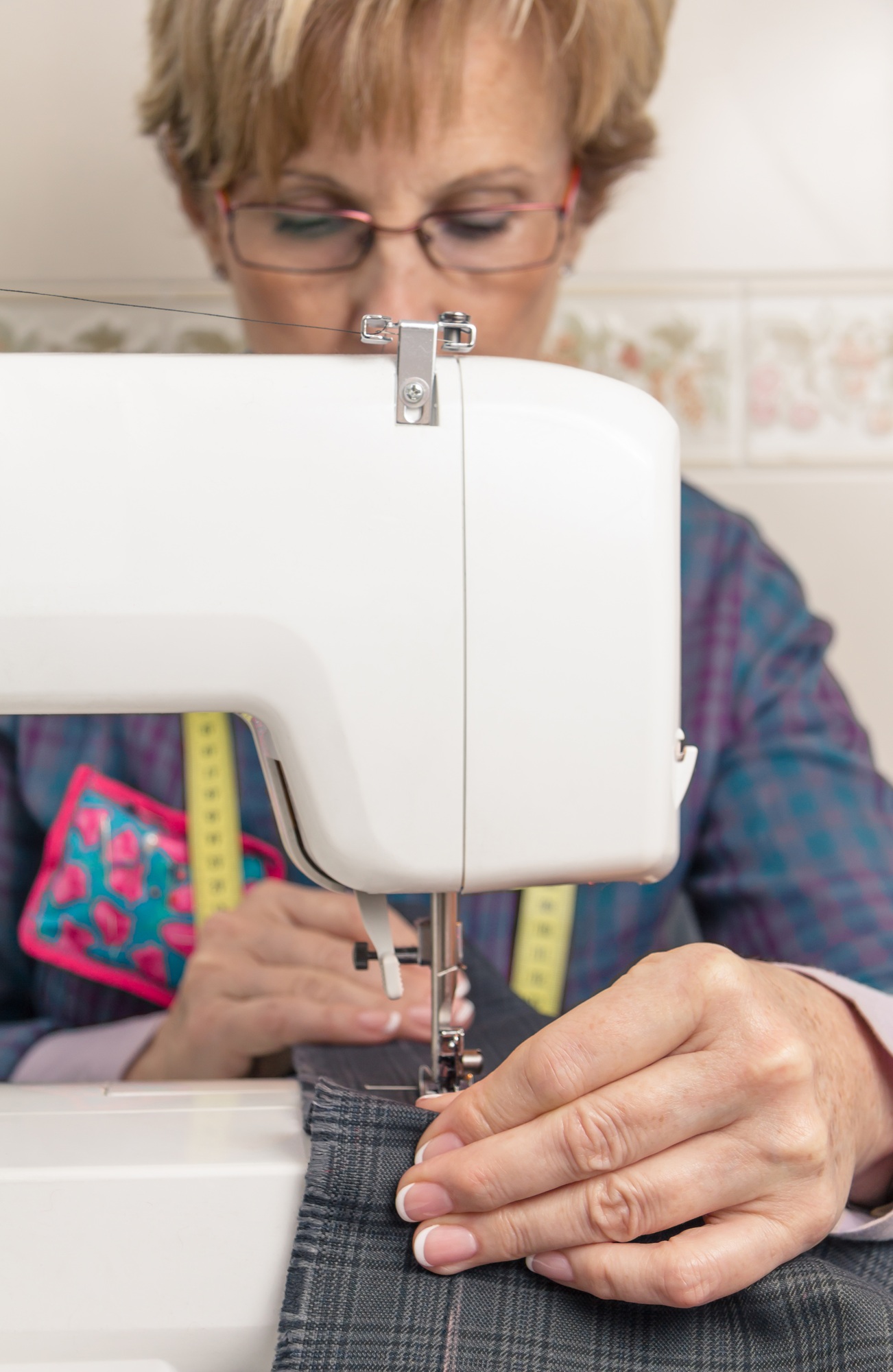 Senion seamstress woman working on sewing machine